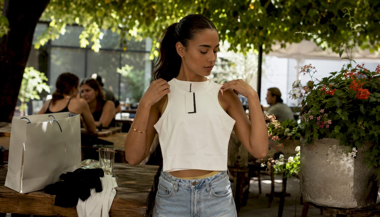 Woman shopping for cropped muscle tank in boutique
