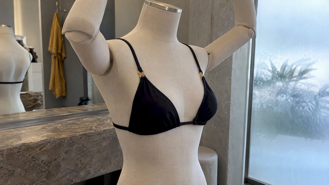 Woman performing bikini top fit test