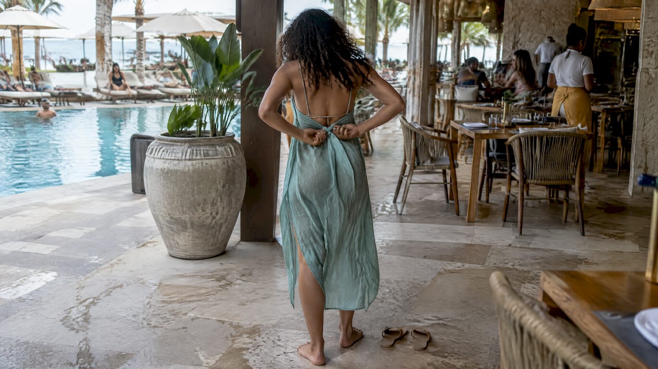 Woman adding a cover-up before entering beach club dining